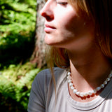 Woman wearing a pearl necklace in a natural setting