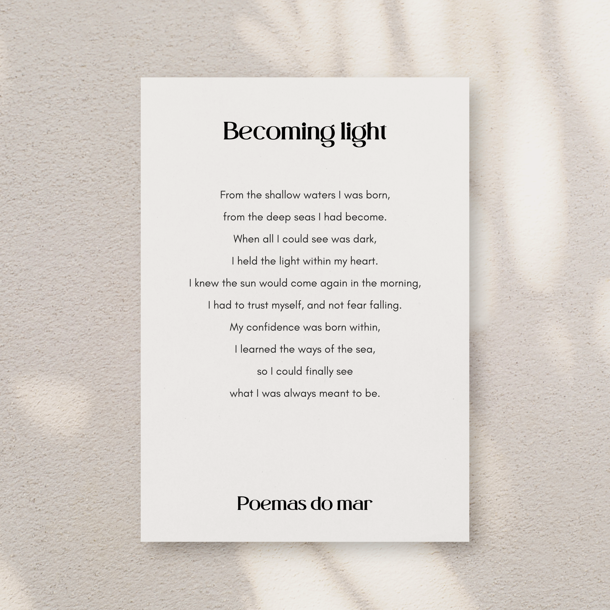 A vertical white art print featuring a poem titled 'Becoming light' by Poemas do mar, displayed against a textured light gray wall with soft shadows.